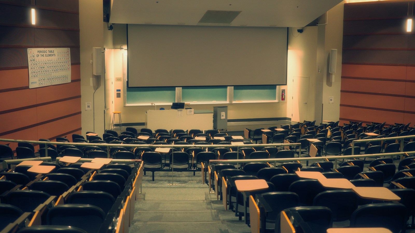 University lecture hall with tiered seating and a large projection screen