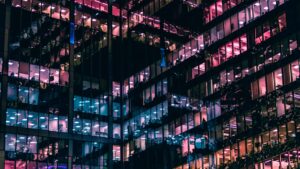 pink, blue, and orange lights from windows out of a large business building