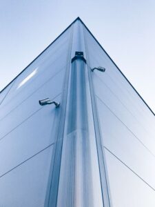 two security cameras on the corner of a tall building